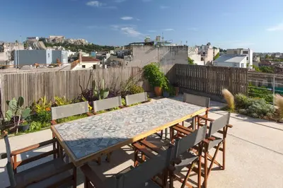 a wooden table and chairs on a patio at Impressive Apartment with Amazing Views - MK1 in Athens