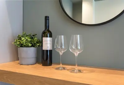 a bottle of wine and two wine glasses on a table at Kolokotroni Lofts Syntagma in Athens