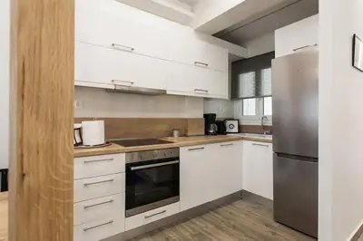 a kitchen with white cabinets and stainless steel appliances at CosmosDome / Best apartment in the heart of Athens ! in Athens