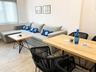a living room with a couch and a table and chairs at CosmosDome / Best apartment in the heart of Athens ! in Athens