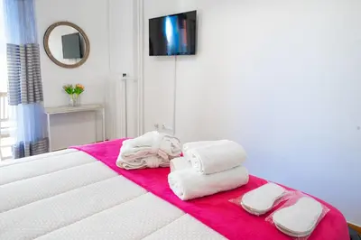a pile of towels sitting on top of a bed at Unique apartment in Glyfada center in Athens