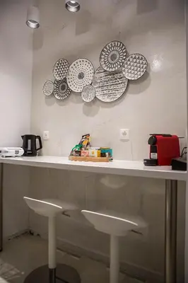 a counter with two stools and plates on the wall at Unique apartment in Glyfada center in Athens
