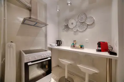 a kitchen with a stove and a counter with stools at Unique apartment in Glyfada center in Athens