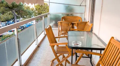 a balcony with chairs and a glass table at Unique apartment in Glyfada center in Athens