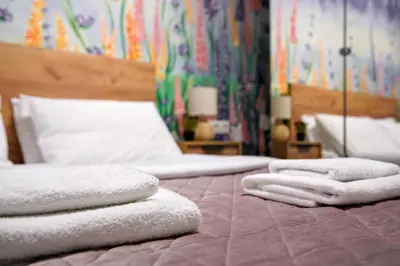 three towels are stacked on top of a bed at Attiki Sunshine Apartment With Terrace VIPGreece in Athens