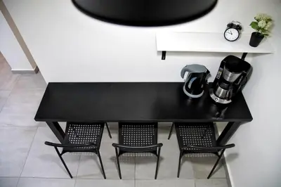 a black table with two chairs and a clock at Attiki Sunshine Apartment With Terrace VIPGreece in Athens