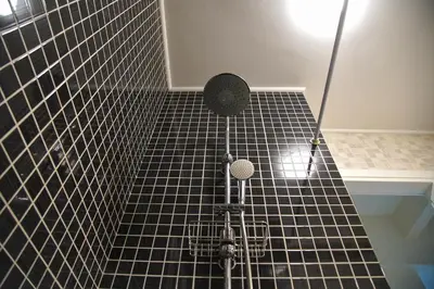 a black tiled bathroom with a shower with a fan at Attiki Sunshine Apartment With Terrace VIPGreece in Athens