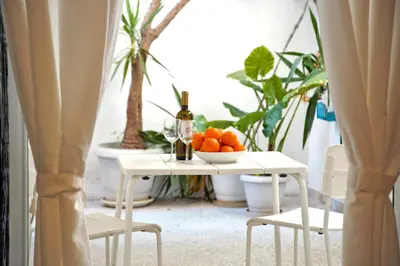 a table with a bowl of oranges and a bottle of wine at Attiki Sunshine Apartment With Terrace VIPGreece in Athens