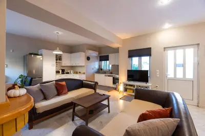 a living room with a couch and a table at Emma's Airport Studio in Spáta