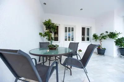 a table and chairs in a room with potted plants at Emma's Airport Studio in Spáta