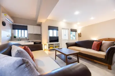 a living room with two couches and a table at Emma's Airport Studio in Spáta