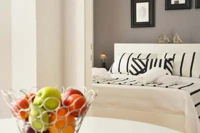 a bedroom with a bed with a bowl of fruit on a table at Athena by Heloni Apartments in Athens