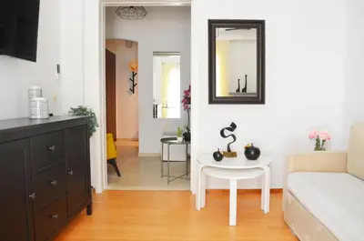 a living room with a white couch and a table at Athena by Heloni Apartments in Athens