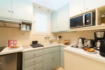 a kitchen with white cabinets and a microwave at Athena by Heloni Apartments in Athens