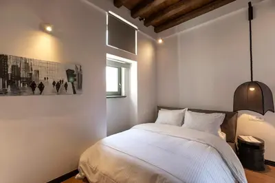 a bedroom with a large white bed and a window at Noma Hotel in Athens