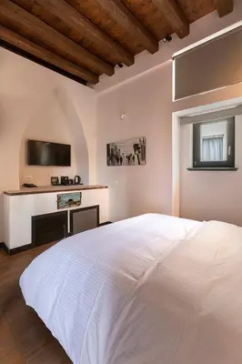 a bedroom with a white bed and a tv at Noma Hotel in Athens