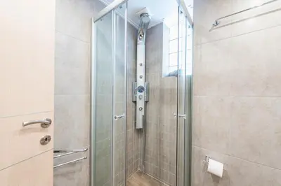 a shower with a glass door in a bathroom at Comfortable,sunny apartment in Athens Center in Athens
