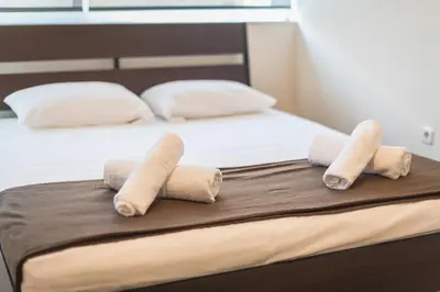a bed with three rolled up towels on it at Comfortable,sunny apartment in Athens Center in Athens