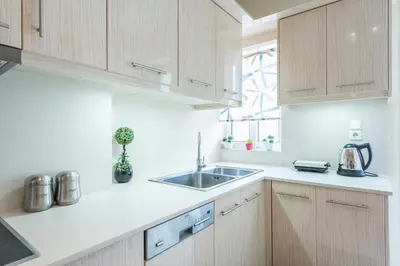 a kitchen with wooden cabinets and a sink at Comfortable,sunny apartment in Athens Center in Athens