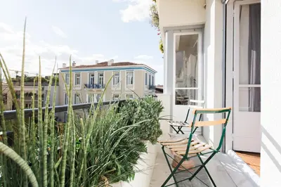 a balcony with two chairs and plants on it at Athens Heritage Suite in Athens