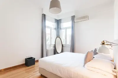 a white bedroom with a bed and a mirror at Athens Heritage Suite in Athens