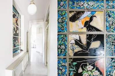 a hallway with a wall of stained glass windows at Athens Heritage Suite in Athens
