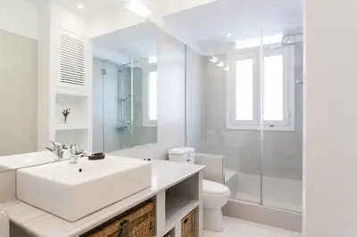 a white bathroom with a sink and a shower at Athens Heritage Suite in Athens