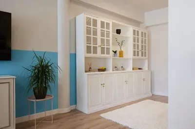 a white cabinet in a room with a potted plant at Athenian Sensations Apartments and Suites in the Heart of Athens in Athens