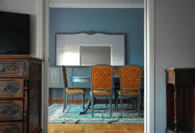 a dining room with a table and chairs and a mirror at Vintage, spacious apartment in the heart of Athens! in Athens