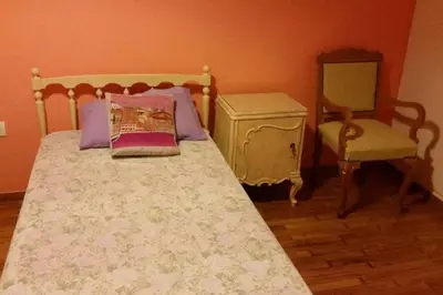 a bedroom with a bed with a dresser and a chair at Vintage, spacious apartment in the heart of Athens! in Athens
