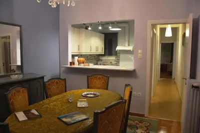 a dining room with a table and a kitchen at Vintage, spacious apartment in the heart of Athens! in Athens