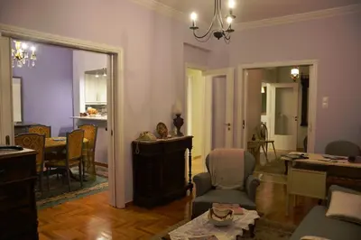 a living room with a couch and a table and chairs at Vintage, spacious apartment in the heart of Athens! in Athens