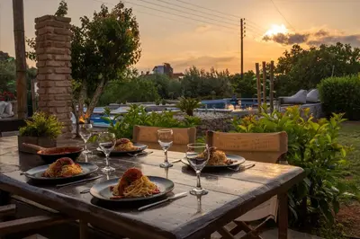 a wooden table with plates of food and wine glasses at Spa Villa34 Family resort Renew, Relax, Revitalise in Aghia Marina
