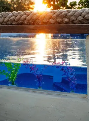 a fishtank sitting under a bench with the water at Spa Villa34 Family resort Renew, Relax, Revitalise in Aghia Marina