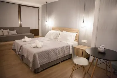 a bedroom with a bed and a couch and a table at 2the Point Athens Suites & Appartments in Plaka in Athens