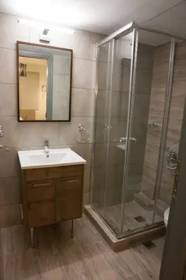 a bathroom with a shower and a sink and a mirror at 2the Point Athens Suites & Appartments in Plaka in Athens