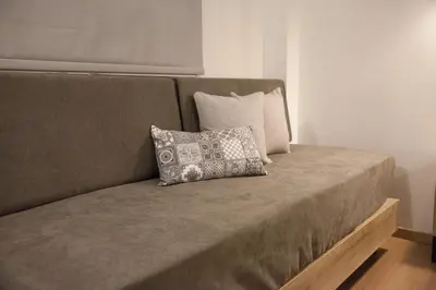 a couch with a pillow on it in a room at 2the Point Athens Suites & Appartments in Plaka in Athens