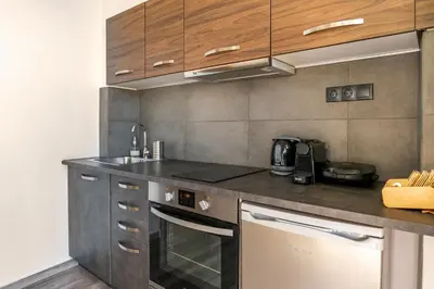 a kitchen with wooden cabinets and a counter top at Dreamy Athens Penthouse With Acropolis View in Athens