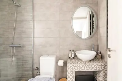 a bathroom with a sink and a toilet and a mirror at Dreamy Athens Penthouse With Acropolis View in Athens