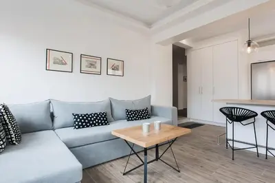 a living room with a blue couch and a table at CosmosDome. Best view in the heart of Athens! in Athens