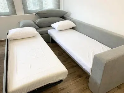 two beds in a room with a couch at CosmosDome. Best view in the heart of Athens! in Athens