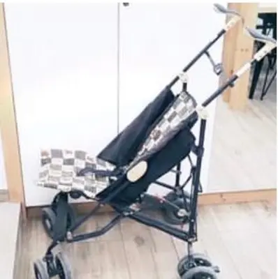 a black stroller sitting in front of a mirror at CosmosDome. Best view in the heart of Athens! in Athens