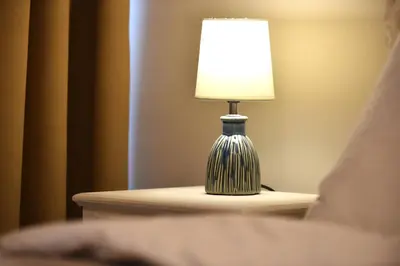 a lamp sitting on a table next to a bed at Cozy Apartment in the Heart of Athens 8-2 in Athens