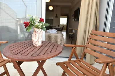 a vase of flowers sitting on a table with two chairs at Cozy Apartment in the Heart of Athens 8-2 in Athens