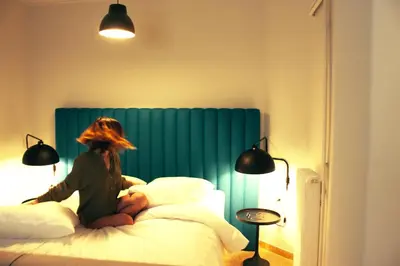 a woman sitting on top of a bed at Athens Blossom House under Acropolis with private entrance in Athens