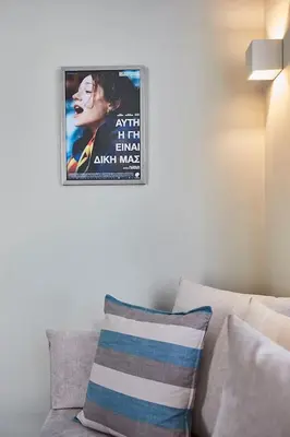 a movie poster hanging on a wall above a couch at Spacious Suite w. huge balcony + Acropolis view in Athens