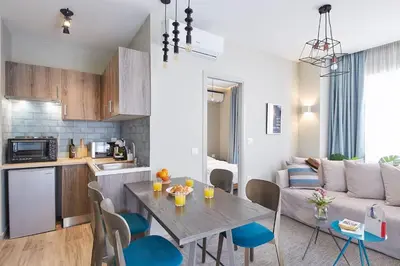 a kitchen and a living room with a table and chairs at Spacious Suite w. huge balcony + Acropolis view in Athens