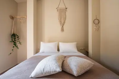 a bedroom with a bed with white sheets and pillows at Stone house near Acropolis - Living Stone Diamond in Athens