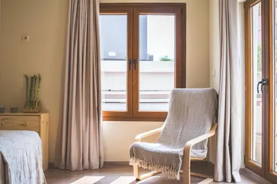 a chair sitting in front of a window at Stone house near Acropolis - Living Stone Diamond in Athens