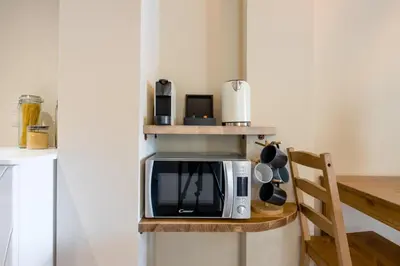 a microwave on a shelf in a kitchen at Stone house near Acropolis - Living Stone Diamond in Athens